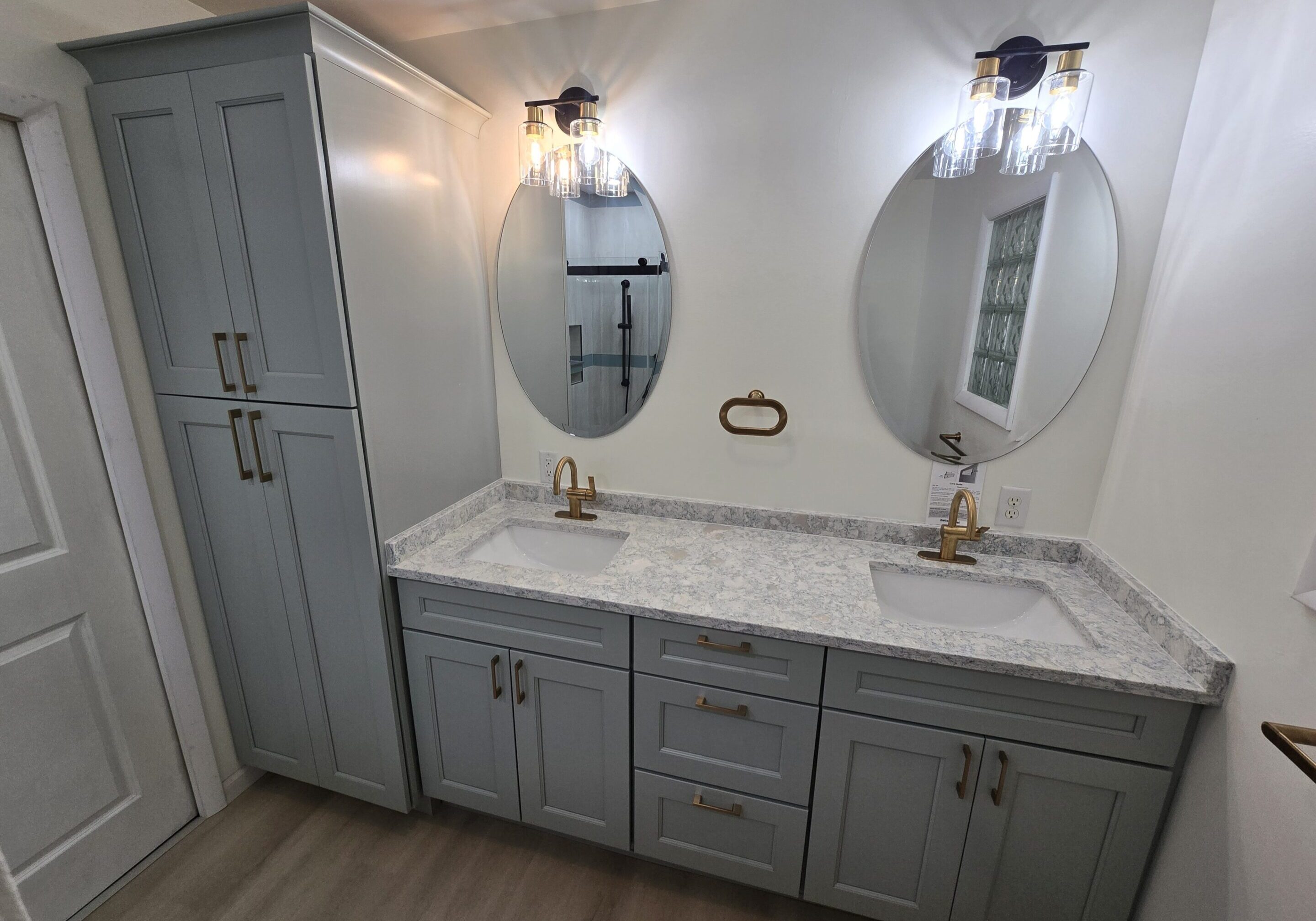 Modern bathroom vanity with dual oval mirrors and marble countertop.